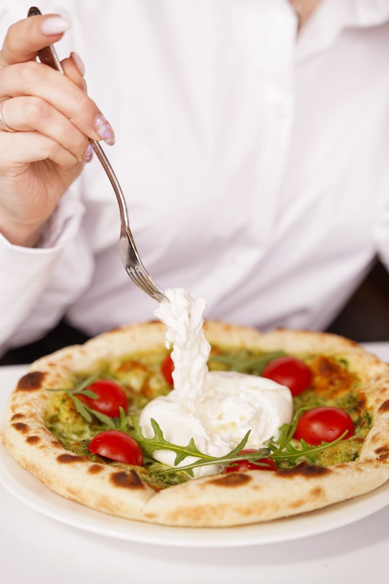 Savor this Italian delight featuring burrata cheese, cherry tomatoes, and fresh arugula on a gourmet pizza.